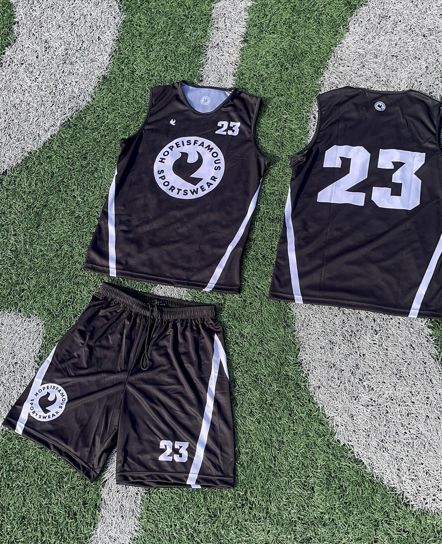 Custom black and light blue Hopeisfamous Sportswear basketball uniform on turf